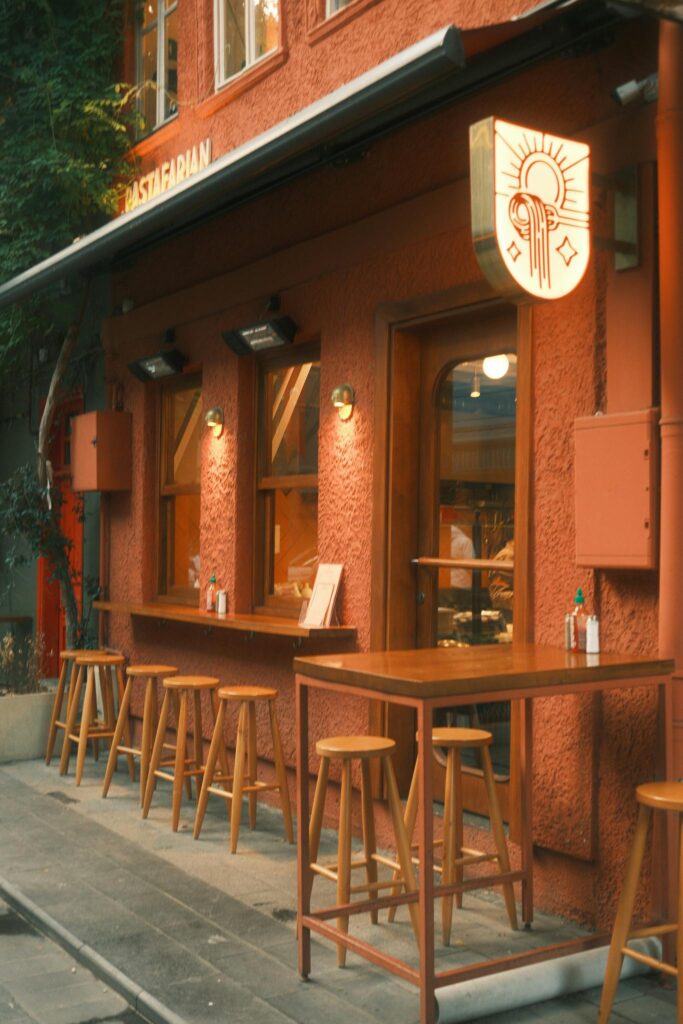 Cozy outdoor cafe with wooden stools and a warm ambiance. Ideal for street photography and urban exploration.